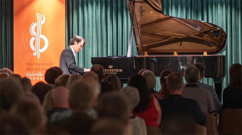 Meister am Piano: Konzerterlebnis auf Stackmanns Bühne in Buxtehude Haiou Zhang sitzt auf der Bühne am Klavier vor voll besetzten Zuschauerreihen