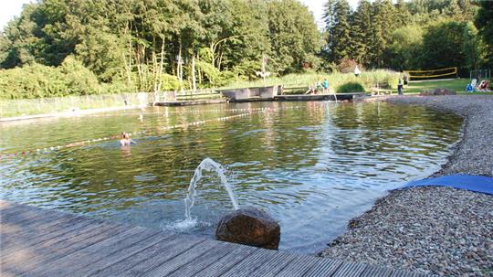 Pluspunkte des Naturbads in Sauensiek: Baden ohne Chemie und weitläufige Liegewiesen. eine blaue Matte (rechts) für über die Kieselsteine.