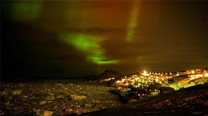 Polarlichter leuchten am frühen Donnerstagmorgen am Himmel über Häusern in Nuuk, Grönland.
