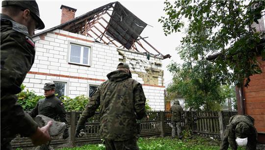 Polen, Wyryki: Beamte der Territorialen Verteidigung räumen Trümmer vom zerstörten Dach eines Hauses auf, nachdem russische Drohnen den polnischen Luftraum verletzt haben. 