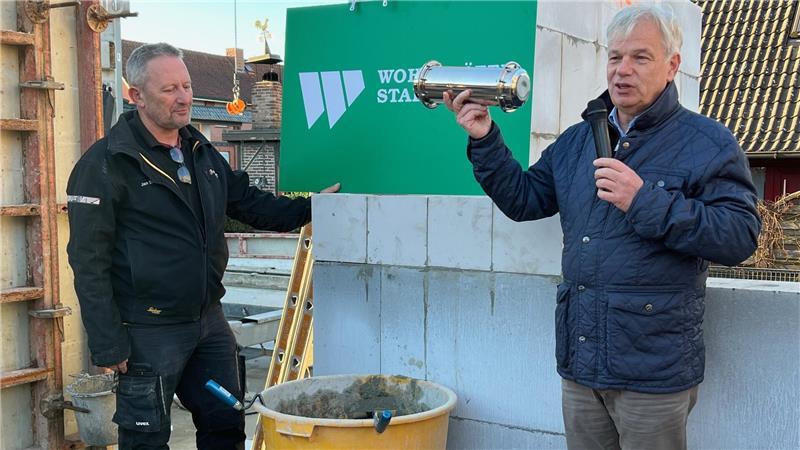 Polier Jan Eversen (links) und Oliver Stapel von der Wohnstätte mauern die Zeitkapsel ein - versehen mit Bauplänen und dem TAGEBLATT.