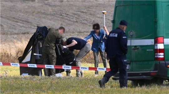  Polizei und Militärpolizei sichern Teile einer beschädigten Drohne, die von polnischen Behörden abgeschossen wurde, auf einem Gelände in Wohyn. 