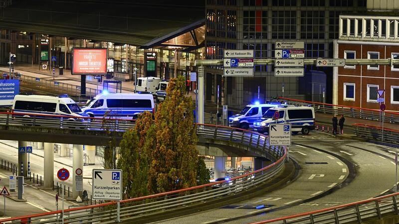 Bewaffneter mit Geisel auf Hamburger Airport Polizeiautos fahren am Flughafen mit Blaulicht entlang.