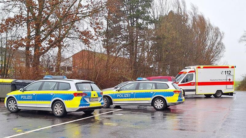 Polizeiautos und ein Krankenwagen stehen nahe einer Schule.