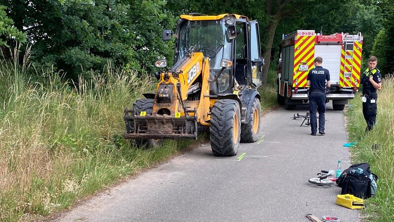 Polizeibeamte sichern neben dem Radlader Spuren.