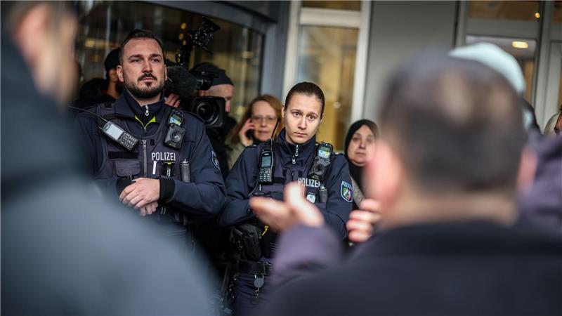 Polizeibeamte sprechen mit möglicherweise betroffenen Kunden der Sparkassenfiliale in Buer.