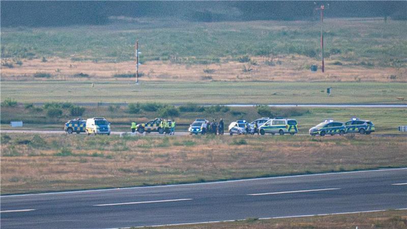 „Klimakleber“ Fabian Beese: „Ich werde weitermachen“ Polizeifahrzeuge und ein Follow-Me Wagen des Flughafen Köln-Bonn stehen auf einer Rollbahn. Aktivisten der Klima-Initiative Letzte Generation haben sich durch den Zaun geschnitten und als Protestaktion auf einer Zufahrt zu einer Start- und Landebahn festgeklebt.