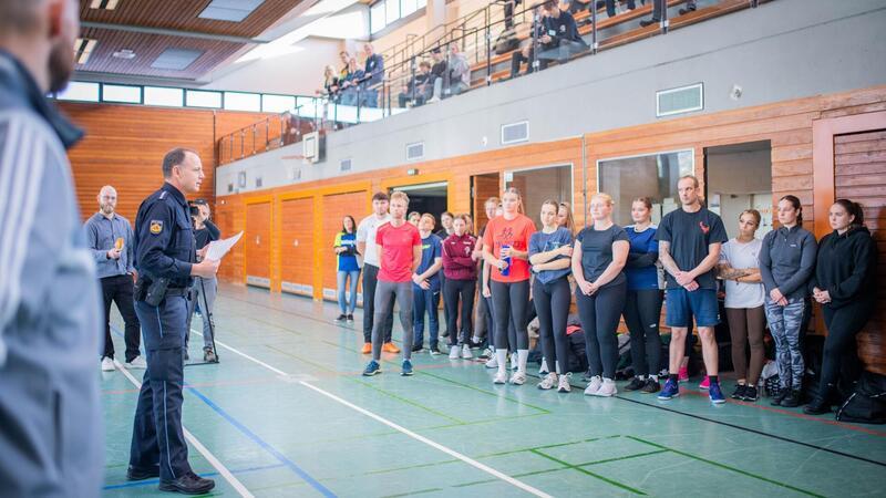 Polizeihauptkommissar Kai Steffens (links) begrüßt die rund 40 Teilnehmer zum Start der sportlichen Herausforderungen in der Turnhalle.