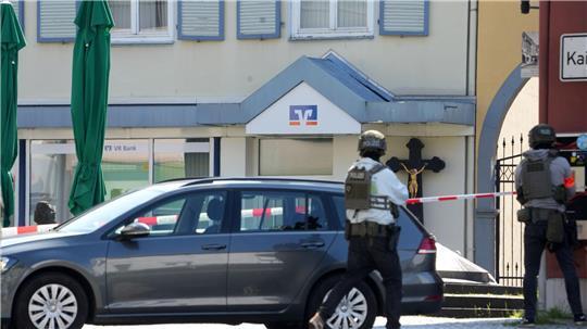 Polizeikräfte halten sich rund um die Bankfiliale bereit. 