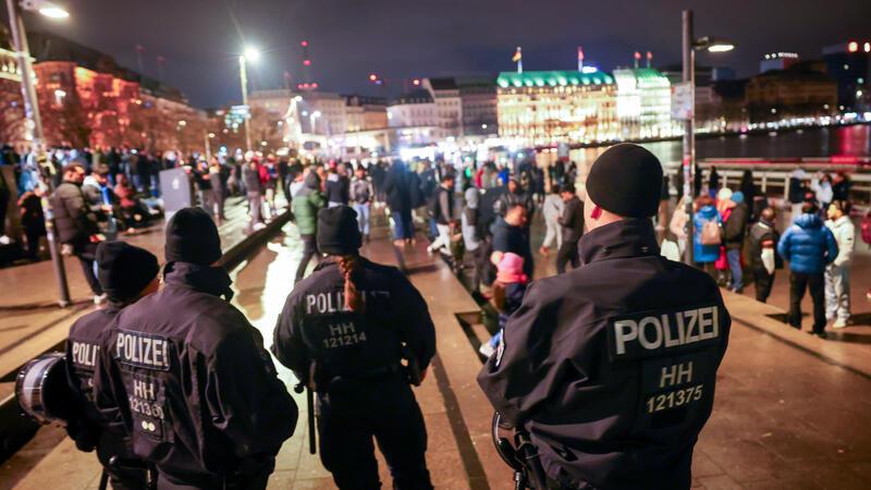 Polizei mit Lageüberblick: So feierten die Hamburger Silvester Polizeikräfte stehen auf dem Jungfernstieg und kontrollieren das Verbot von Feuerwerk an der Binnenalster kurz vor dem Jahreswechsel.