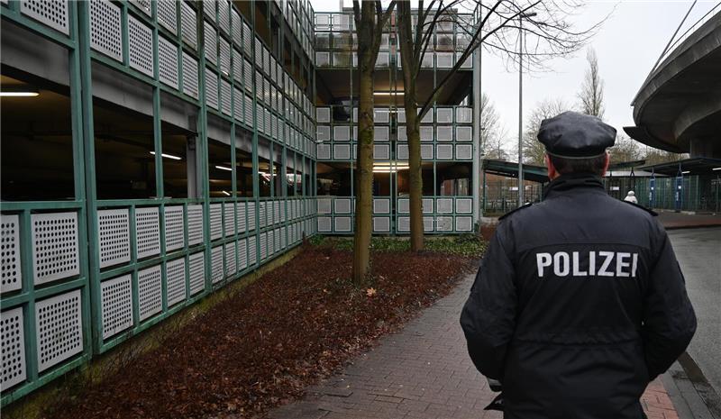 Polizeisprecher Rainer Bohmbach steht am Tatort, links ist das Parkhaus am Bahnhof zu sehen.
