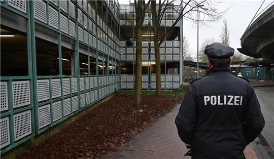 Polizeisprecher Rainer Bohmbach steht am Tatort, links ist das Parkhaus am Bahnhof zu sehen.