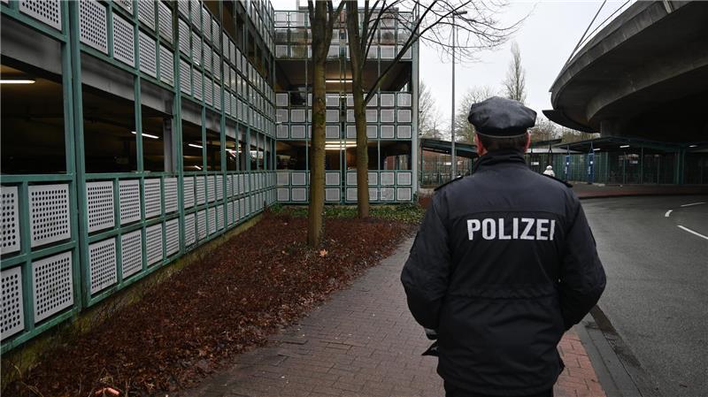Polizeisprecher Rainer Bohmbach steht am Tatort, links ist das Parkhaus am Bahnhof zu sehen.