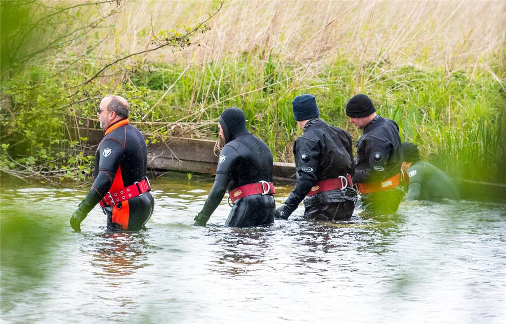 Polizeitaucher gehen auf der Suche nach einem vermissten Jungen einen Tümpel ab....