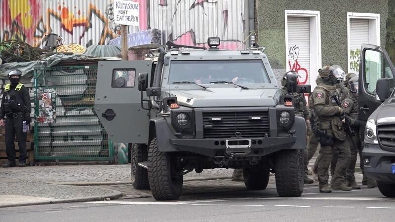 Polizei durchsucht bei RAF-Fahndung Wagenburg – Keine Festnahme Polizisten an einem gepanzerten Fahrzeug.