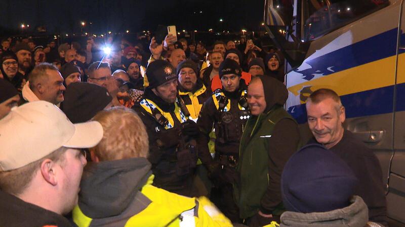 Polizisten diskutieren mit uneinsichtigen Landwirten.