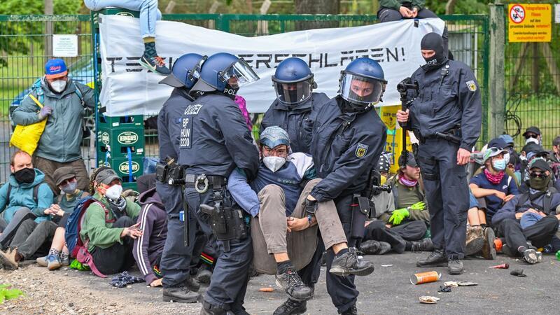 Polizisten gehen gegen eine Blockade an der Zufahrt zum Flugplatz Neuhardenberg vor.