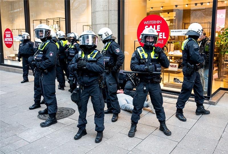 Polizisten halten in der Einkaufsstraße Mönkebergstraße einen Jugendlichen fest. In der Hamburger Innenstadt ist es am Nachmittag zu einer Auseinandersetzung zwischen Dutzenden Jugendlichen und jungen Erwachsenen sowie der Polizei gekommen. Foto: Daniel Bockwoldt/dp