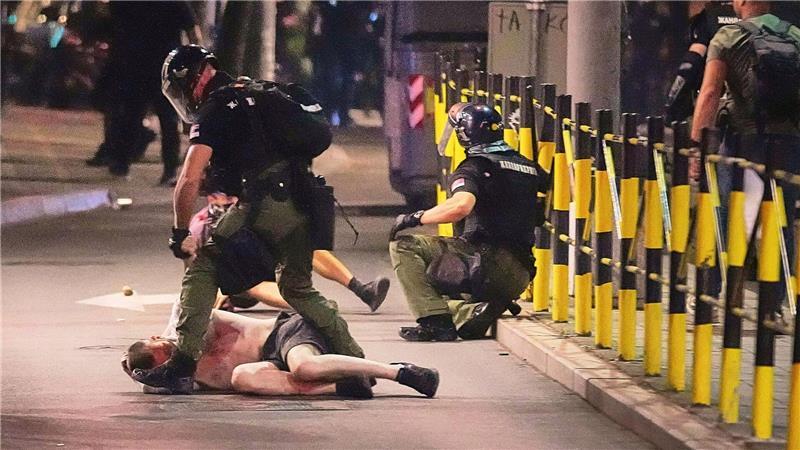 Polizisten in Schutzbekleidung nehmen einen Mann fest, nachdem sie Demonstranten am Ende einer Anti-Regierungs-Kundgebung angegriffen hatten, die auf eine vorgezogene Wahl drängten. 