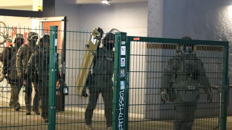 Polizisten in Spezialausrüstung verlassen ein Hochhaus in Berlin-Friedrichshain.