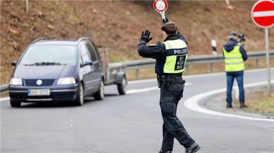 Polizisten kontrollieren ein Auto (Symbolbild).