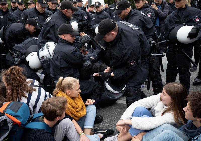Polizisten lösen eine Sitzblockade auf dem Stephansplatz nach einer Demonstration auf. Foto: Christian Charisius/dpa