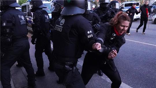 Polizisten rangeln mit einer Demonstrantin nach einer Demonstration in Hamburg gegen die Verurteilung der mutmaßlichen Linksextremistin Lina E.. Foto: Marcus Brandt/dpa