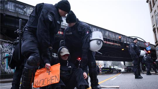 Polizisten sichern Proteste von Menschen gegen den Beginn der Abrissarbeiten an der Hamburger Sternbrücke.