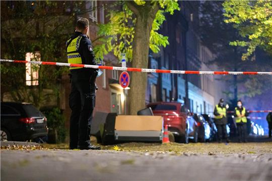 Polizisten sichern einen abgesperrten Tatort. In Hamburg-Harburg sind am Sonntagnachmittag Schüsse gemeldet worden. Zwei Menschen seien möglicherweise verletzt, sagte ein Mitarbeiter beim Lagedienst der Polizei. Foto: Jonas Walzberg/dpa
