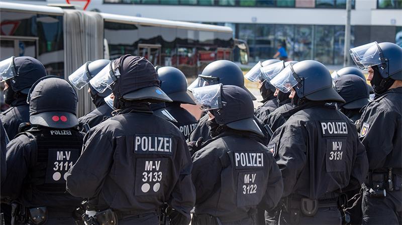 Polizisten sichern vor dem Hauptbahnhof in Rostock die Anreise von Fußballfans des FC St. Pauli Hamburg. Foto: Stefan Sauer/dpa
