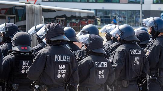 Polizisten sichern vor dem Hauptbahnhof in Rostock die Anreise von Fußballfans des FC St. Pauli Hamburg. Foto: Stefan Sauer/dpa