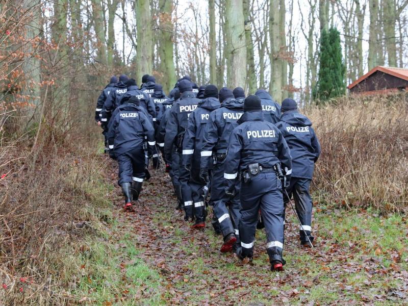 Polizisten sind in einem Wald auf einem Einsatz. Foto: Bernd Wüstneck/dpa/Symbolbild