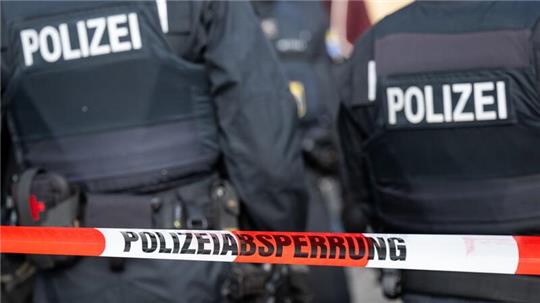 Polizisten stehen hinter einem Polizei-Flatterband (Symbolbild).