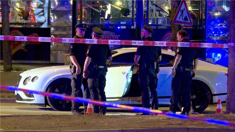 Polizisten stehen im August 2018 neben dem Bentley des angeschossenen Rockers. (Archivbild)