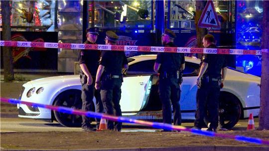 Polizisten stehen im August 2018 neben dem Bentley des angeschossenen Rockers. (Archivbild)