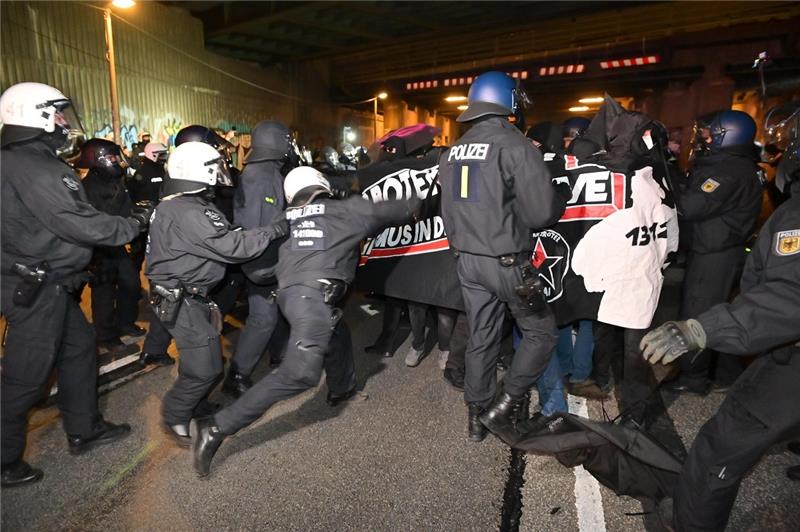 Polizisten stoppen mit dem Einsatz ihrer Schlagstöcker die linksextreme Demonstration am Sonntagabend. Foto: Jonas Walzberg/dpa