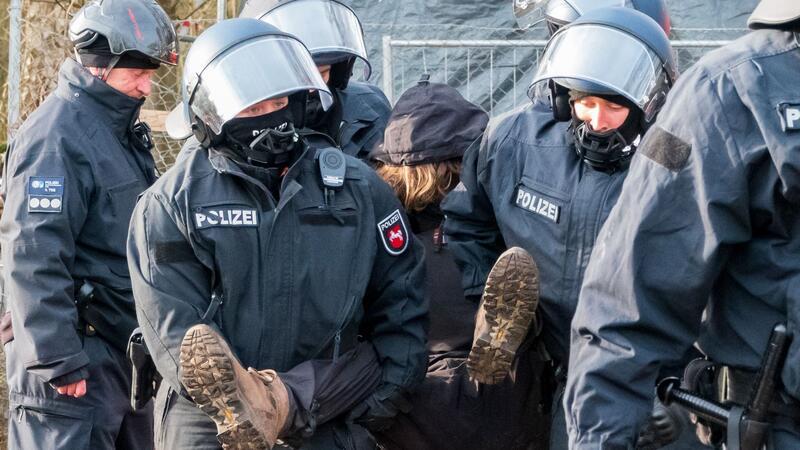 Polizisten tragen einen Demonstranten weg bei der Räumung des Protestcamps „Tümpeltown“.