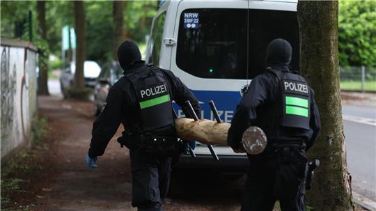 Polizisten tragen einen Rammbock.