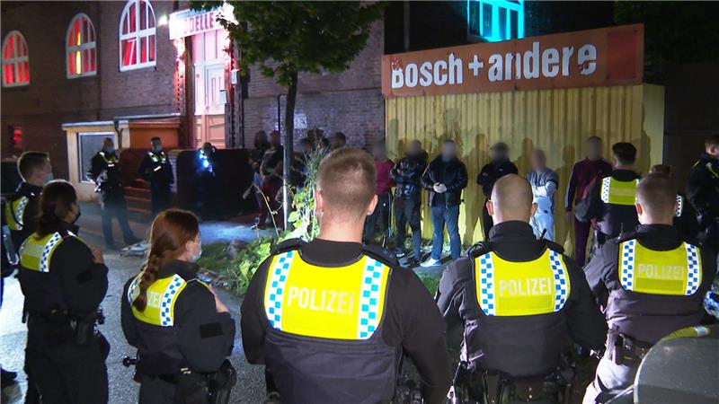 Polizisten umringen mehrere Männer in der Nähe eines Bordells. Der Streit um die Bezahlung in einem Bordell in Hamburg hatte sich am Dienstagabend zu einer Massenschlägerei mit rund 20 Beteiligten entwickelt. Foto: Steven Hutchings/dpa