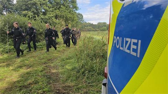 Polizisten und Polizistinnen suchen bei Wunstorf in der Region Hannover nach Drohnenteilen.
