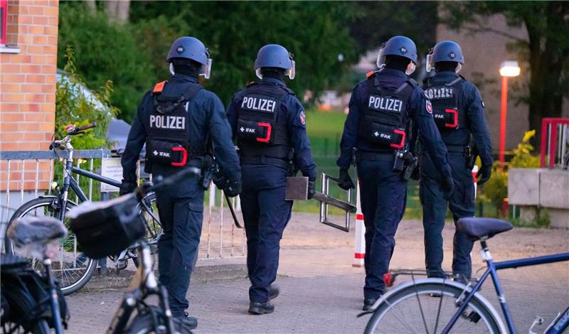 Polizisten verlassen nach einer Durchsuchung ein Wohngebiet. Symbolfoto: dpa