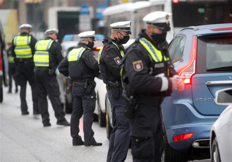 Polizisten verteilen im Rahmen einer Großkontrolle Strafzettel an Autofahrer, die sich nicht an das Durchfahrtsverbot für den Jungfernstieg halten. Foto: Markus Scholz/dpa