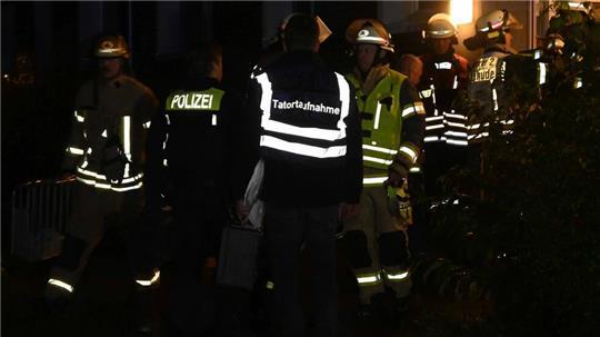 Polizisten vor dem Wohnhaus, die Tatortgruppe sichert - nach dem Einsatz der Feuerwehr - die Spuren des Verbrechens.