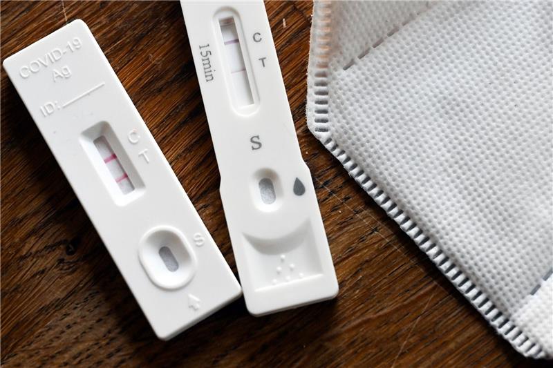 Positive Corona-Selbsttests und eine FFP2-Schutzmaske liegen auf einem Tisch. Die bundesweite Sieben-Tage-Inzidenz ist erneut gestiegen.