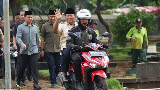 Prabowo Subianto wird von einem Polizisten zum Grab seines Vaters in Jakarta gefahren.