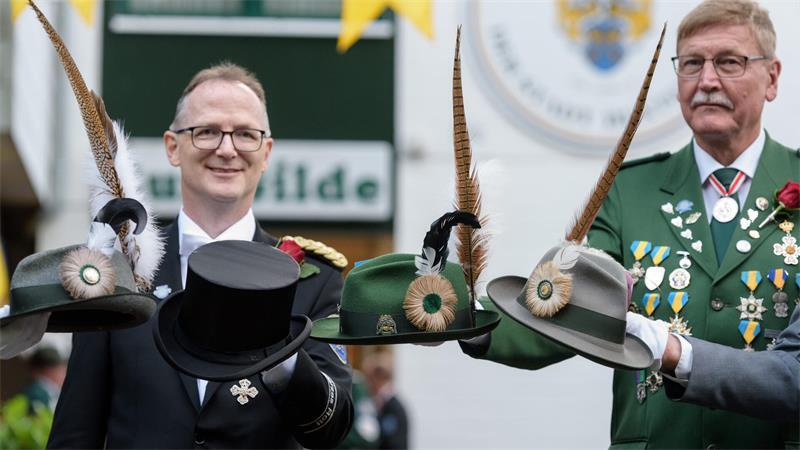 Zapfenstreich in Buxtehude: Das steckt hinter der Schützenfest-Tradition Präsident Reinhard Meier (links) mit dem Zylinder des Schwarzen Rotts und der amtierende König Jürgen Meyer mit dem Hut des Grünen Rotts. Links und Rechts die Hüte des Joppenrotts.