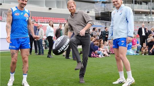 Prinz Harry (M), Herzog von Sussex, kickt einen Football.
