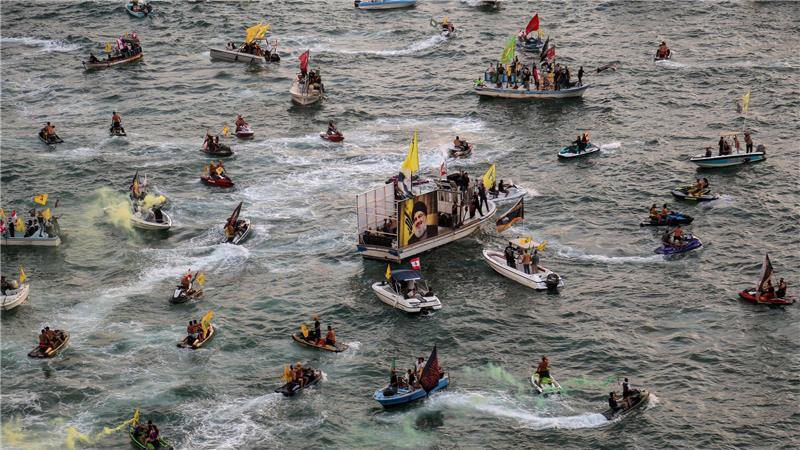 Bilder des Tages Pro-iranische Hisbollah-Anhänger auf kleinen Booten paradieren in der Nähe des libanesischen Taubenfelsens während einer Veranstaltung zum ersten Jahrestag der Tötung von Parteichef Hassan Nasrallah.