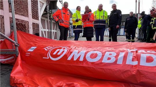 Probelauf: Mobildeich-Erfinder Dr. Walter Wagenhuber blickt mit Lara Stappenbeck, Stephanie Kock, Wilhelm Ulferts und Jens Lohmann auf den flexiblen Hochwasserschutz an der Brücke in Moorende (von links).