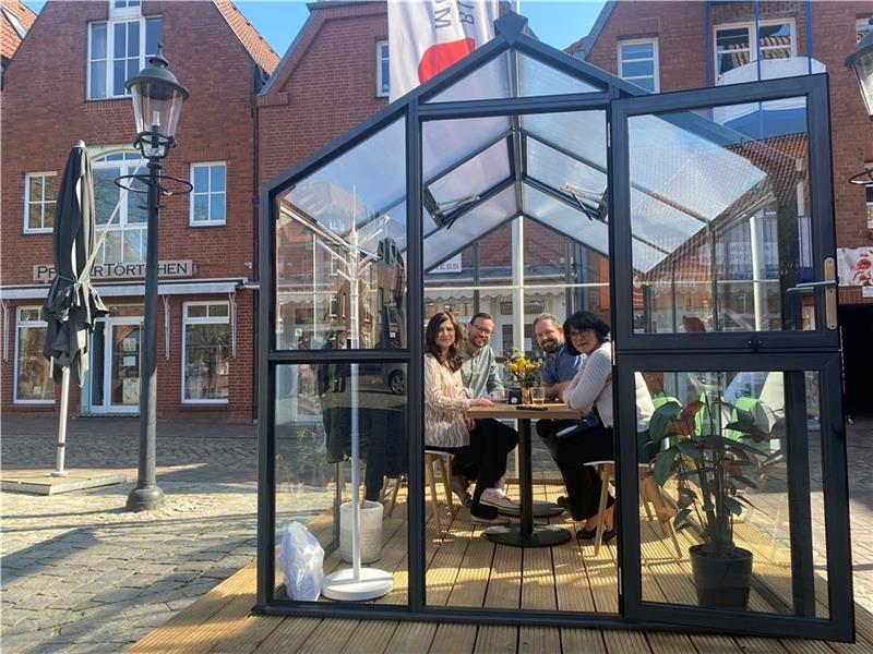 Das erste Glashaus auf dem Petri-Platz ist bezogen – Was es damit auf sich hat Probesitzen in dem ersten eingeFoto: Weselmann